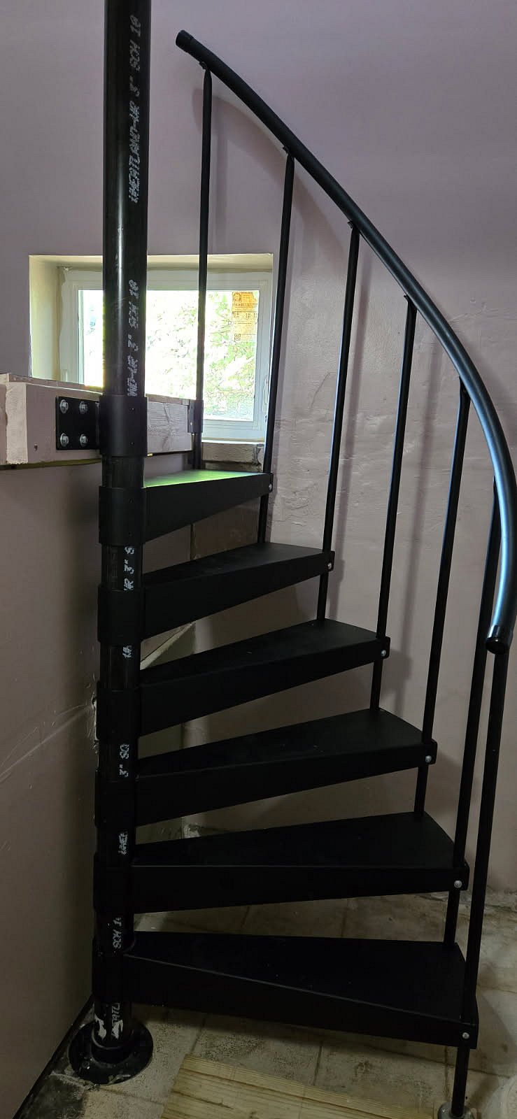 Spiral staircase from entry landing to basement