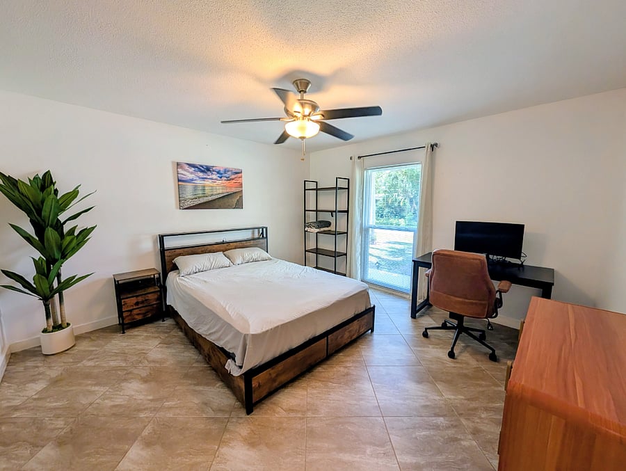 Bedroom with desk and queen bed.