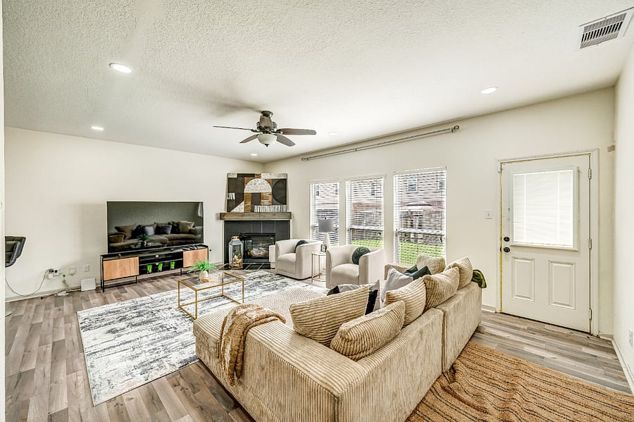 Open and comfortable living space with a large couch, additional seating, and plenty of room to relax, socialize, or watch TV.