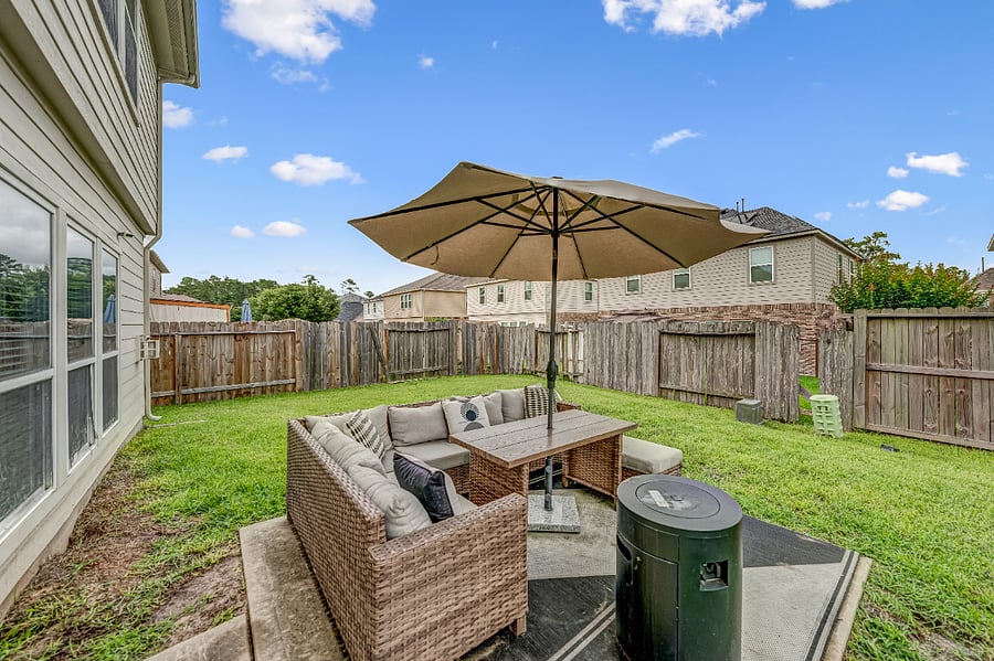 Relax outdoors on the covered patio featuring a patio table, seating, and umbrella ideal for morning coffee or evening meals.