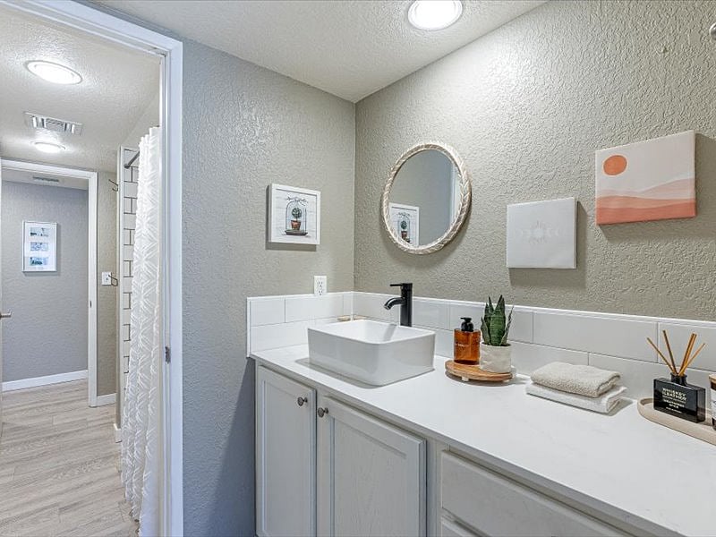Beautifully updated bathroom with hair dryer, curling iron, shampoo, conditioner, and body wash