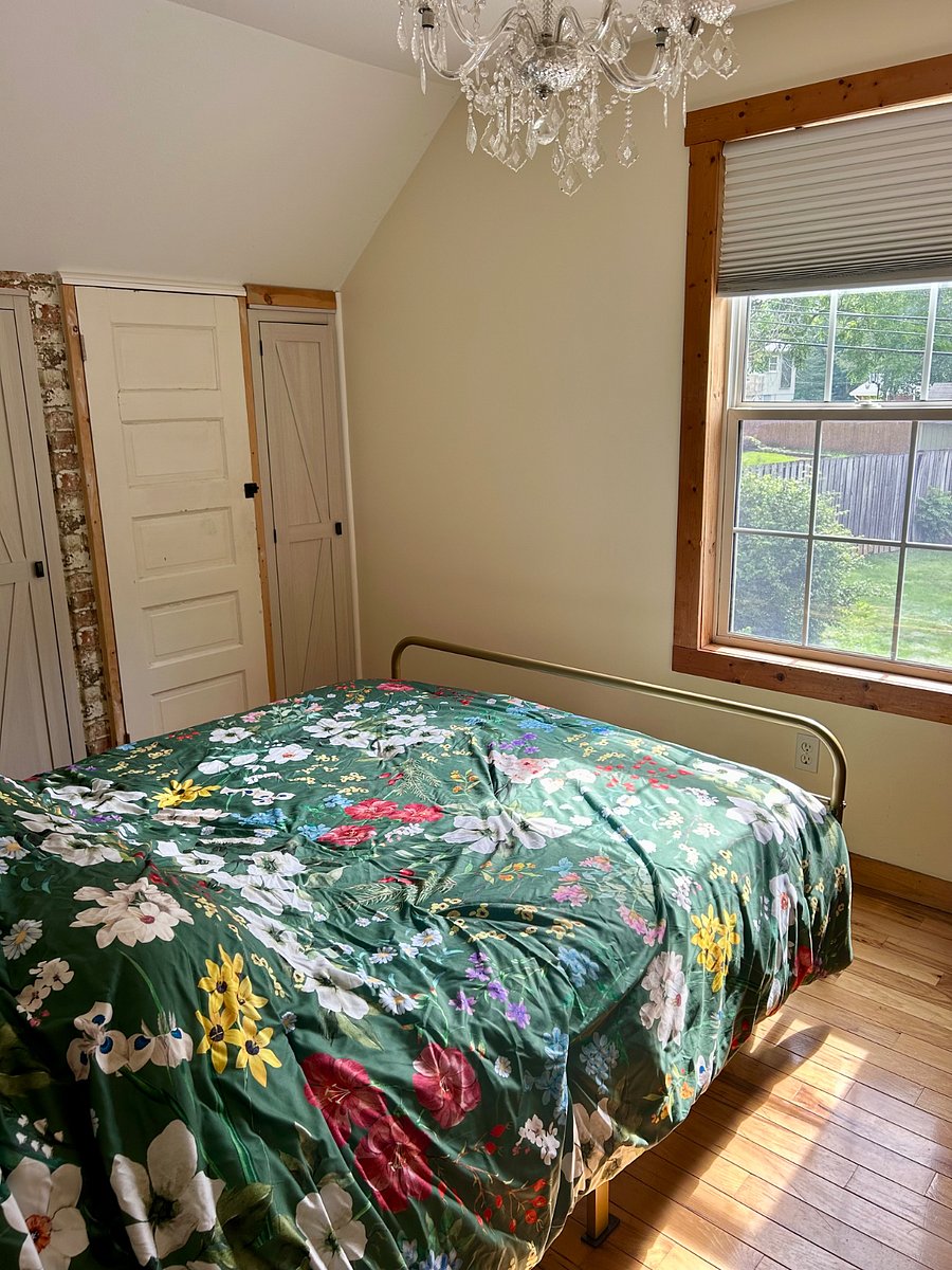 Comfy new queen size bed and chandelier in bedroom