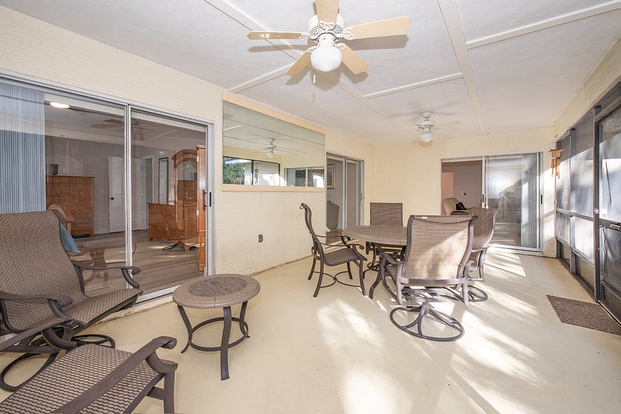 Spacious screened in porch with 4-seat table and side chars.