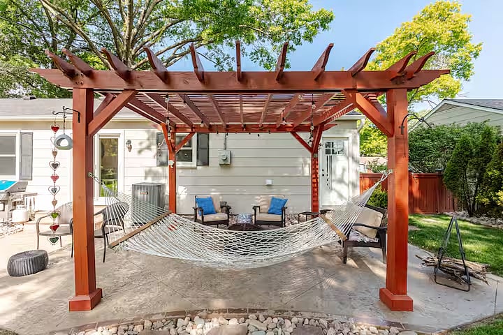 Peaceful patio with comfortable seating, a fire pit, and a large fenced backyard