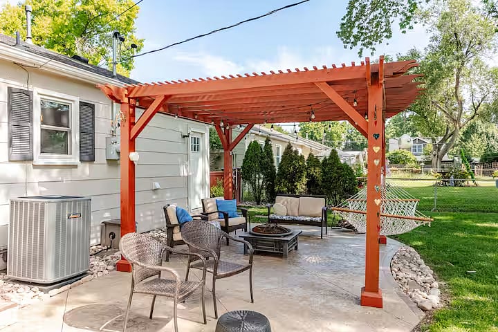 Peaceful patio with comfortable seating, a fire pit, and a large fenced backyard