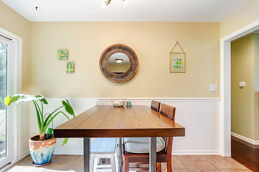A comfortable dining area with convenient backyard access. comfortably sits six people