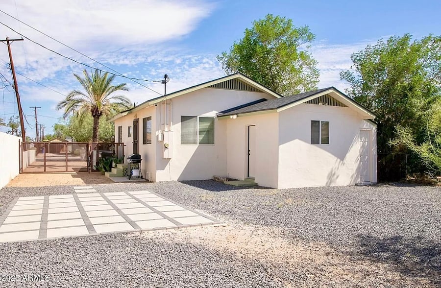 Outdoor living space features gated, fenced back yard with patio. Lounging chair is available. 