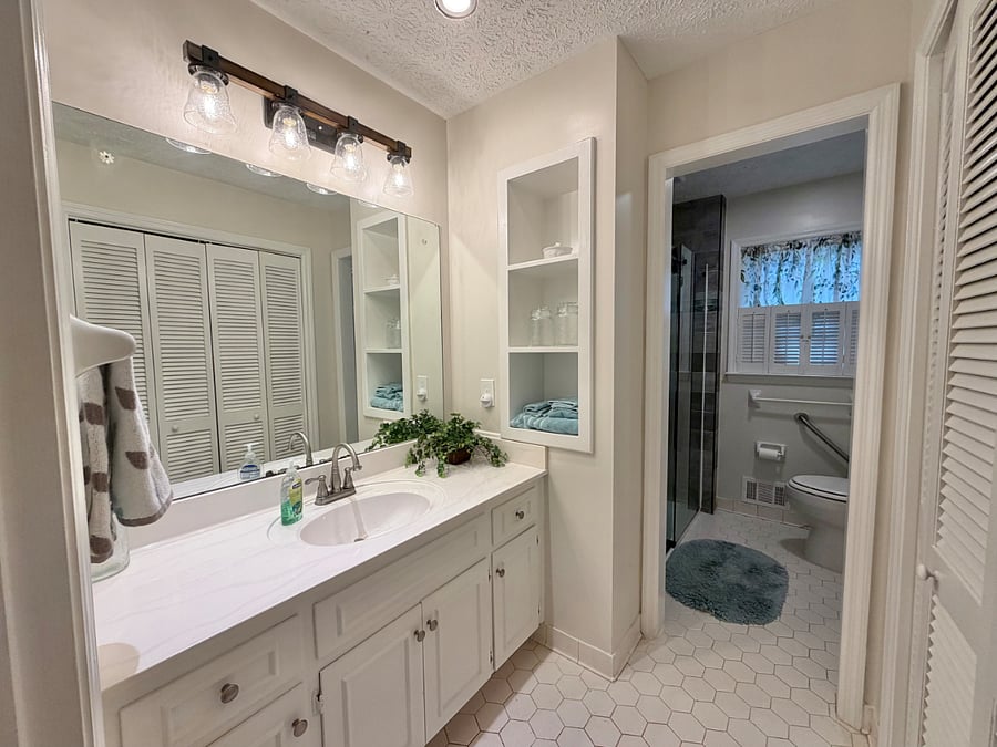 Downstairs bedroom has en suite bathroom with separate sink vanity and shower areas.