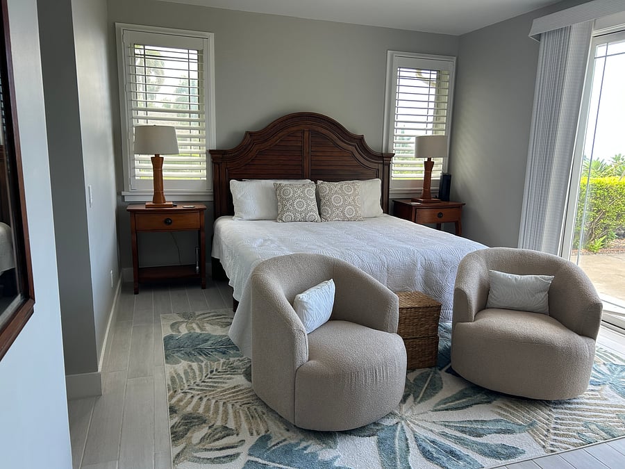 Luxurious primary suite provides a comfy king bed.  Uber comfortable swivel chairs for reading or watching the birds.  Out the slider is your own lanai 
