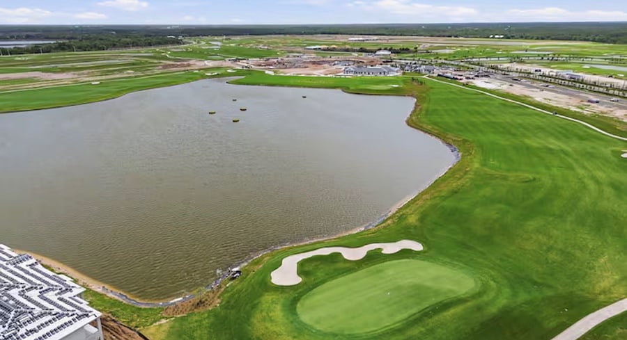 Lake with aqua driving range and view of the 1st. hole.  In the far side of the lake is the country club.