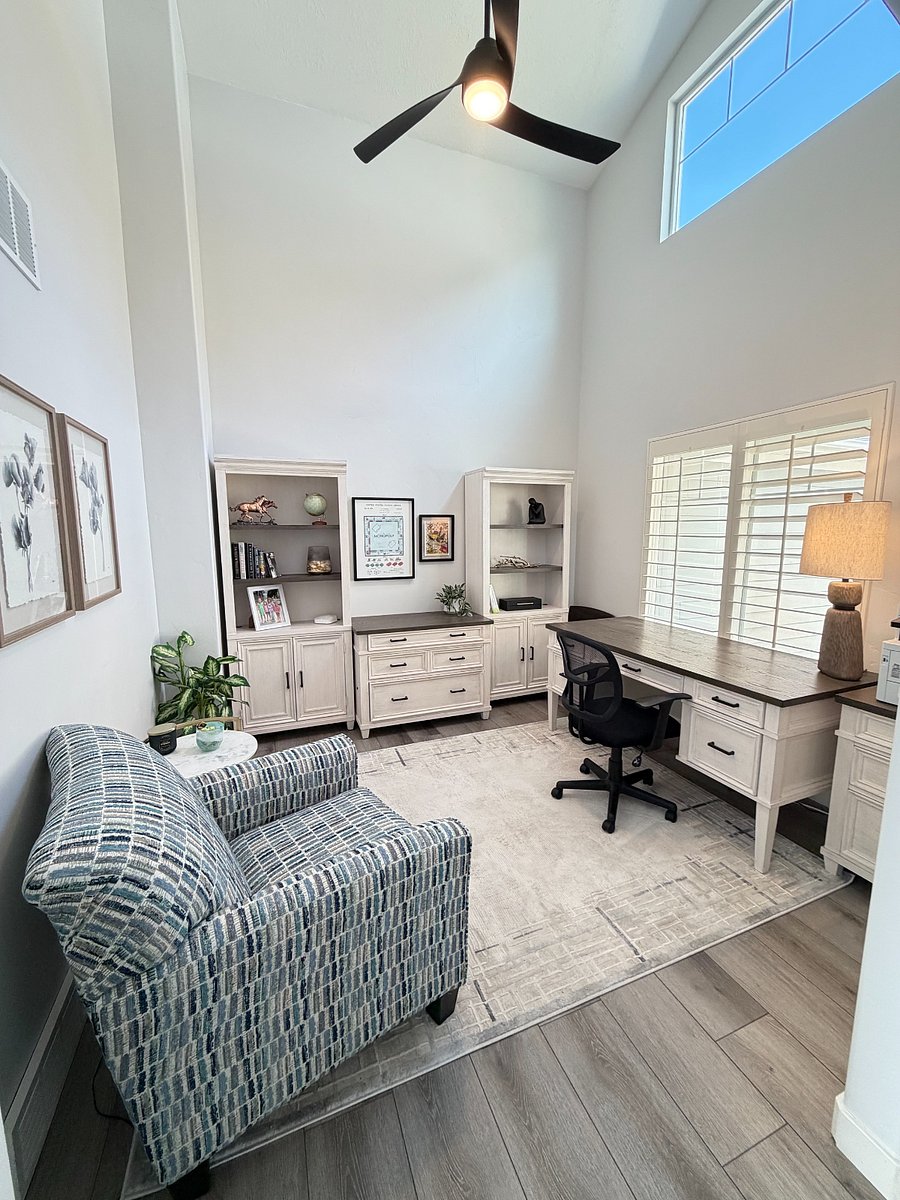 Dedicated work-from-home space with soaring 15-foot ceilings, abundant natural light, and a spacious desk.