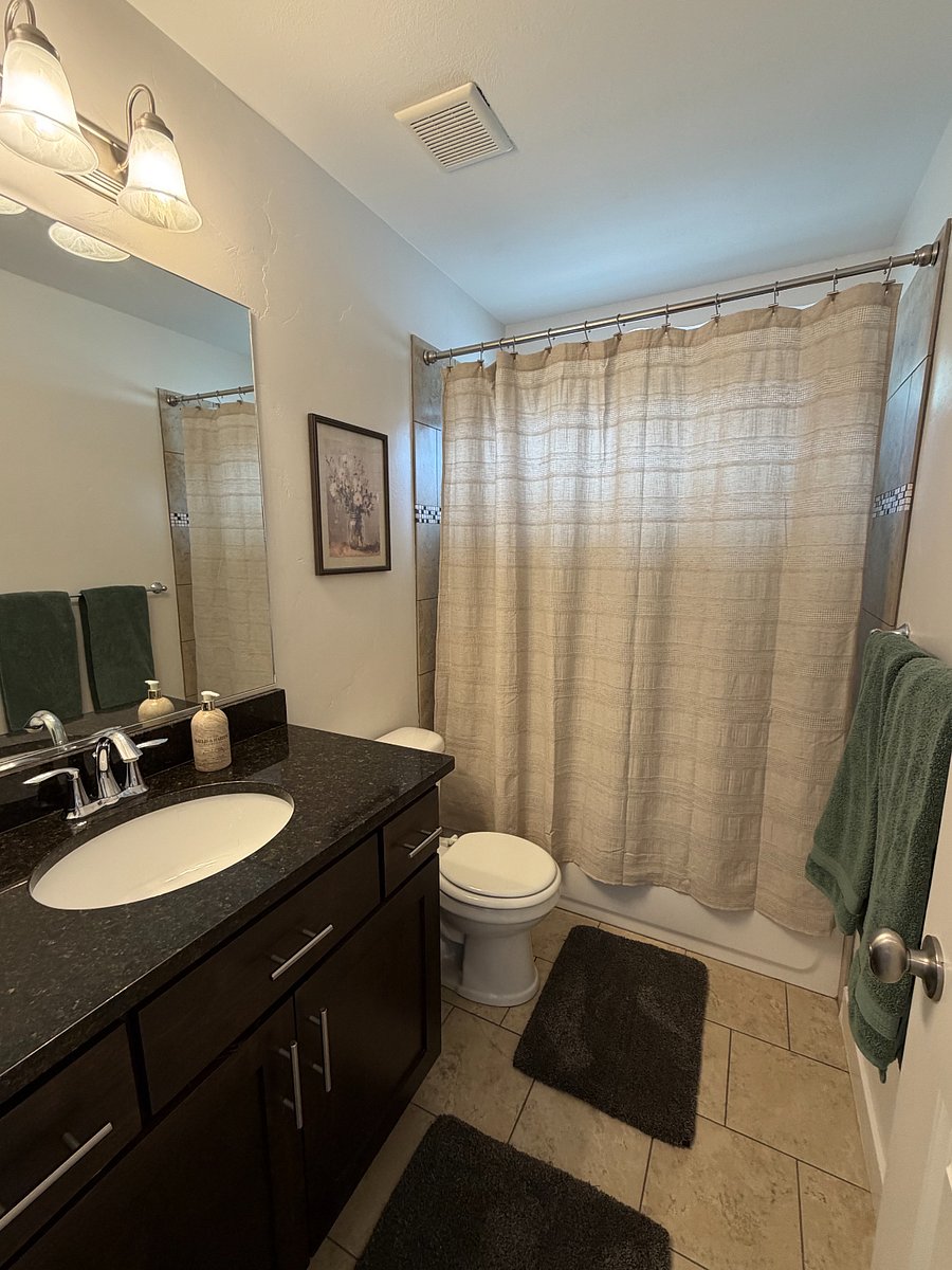 Main floor hall bath with tub/shower combination and granite vanity.