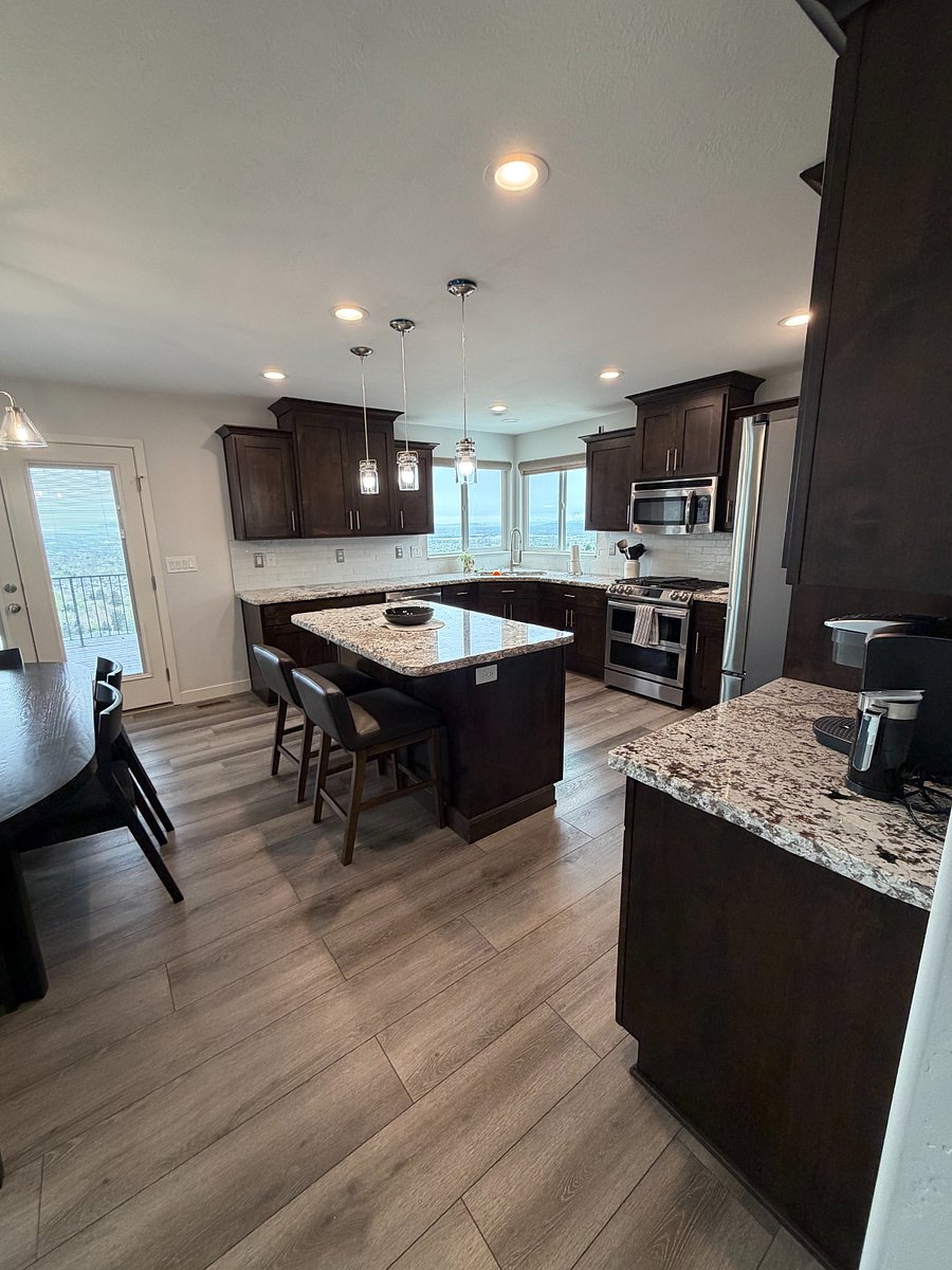 Well-appointed kitchen with granite countertops, center island and corner window views.