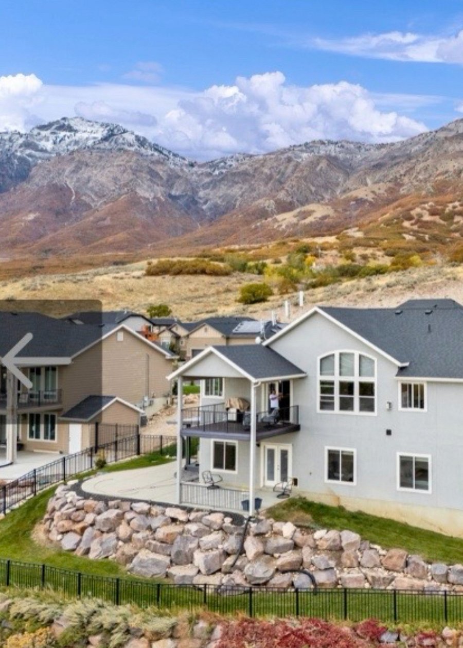 Aerial perspective showing the home's elevated hillside setting and surrounding mountain landscape.