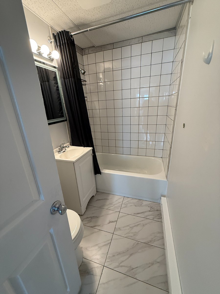 Full bathroom with tiled shower walls.