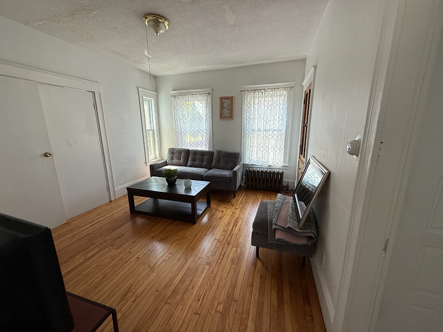 Living room with beautiful hardwood floors. Mirror to be hung after holiday.
