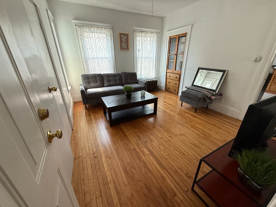 Living room with beautiful hardwood floors. Mirror to be hung after holiday