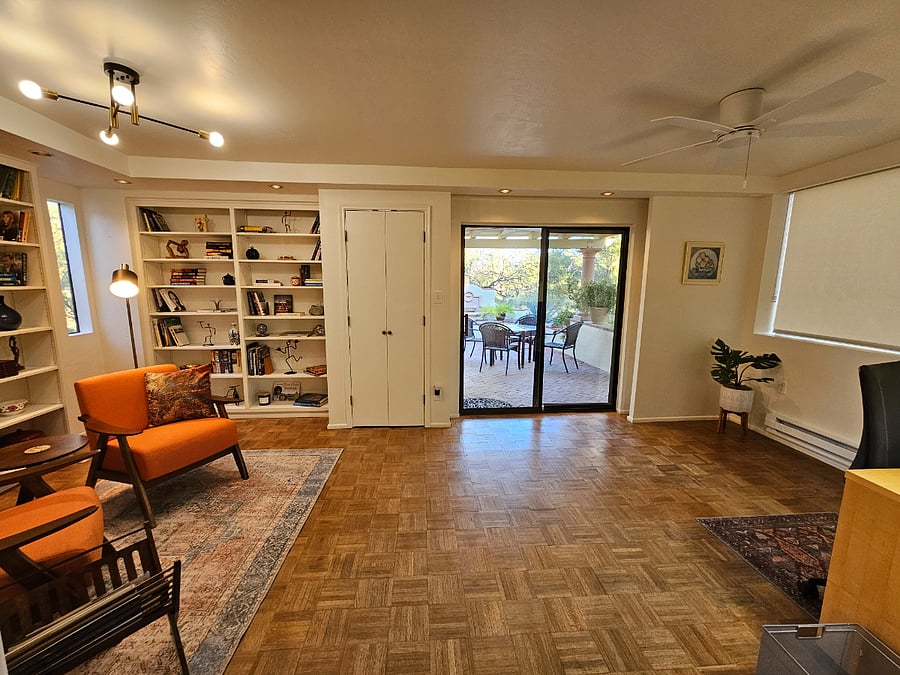 Office/study with dedicated workspaces.  Entrance to rear covered patio. Reading nook with books, games and 2 work spaces.