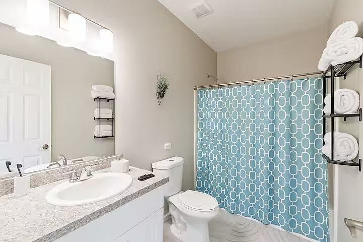 Clean and modern bathroom with a full shower, fresh towels, and bright lighting, everything you need for a comfortable and refreshing stay.