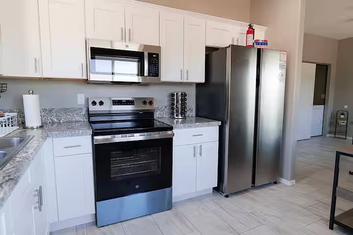 Fully equipped kitchen featuring stainless steel appliances, ample counter space, and everything you need to cook and feel at home. Pots are located in lower cabinets.
