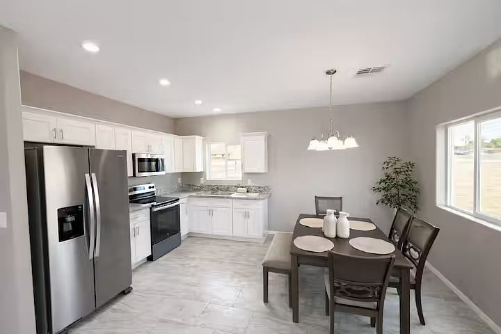 Bright dining area next to the fully equipped kitchen, perfect for family meals, takeout nights, or working remotely. Open layout with plenty of natural light and seating for 4-5 people.