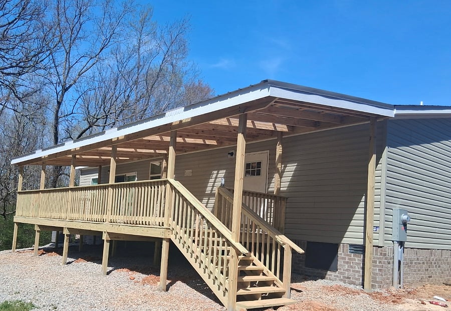 Covered back porch has a lovely view of the wooded back acres.