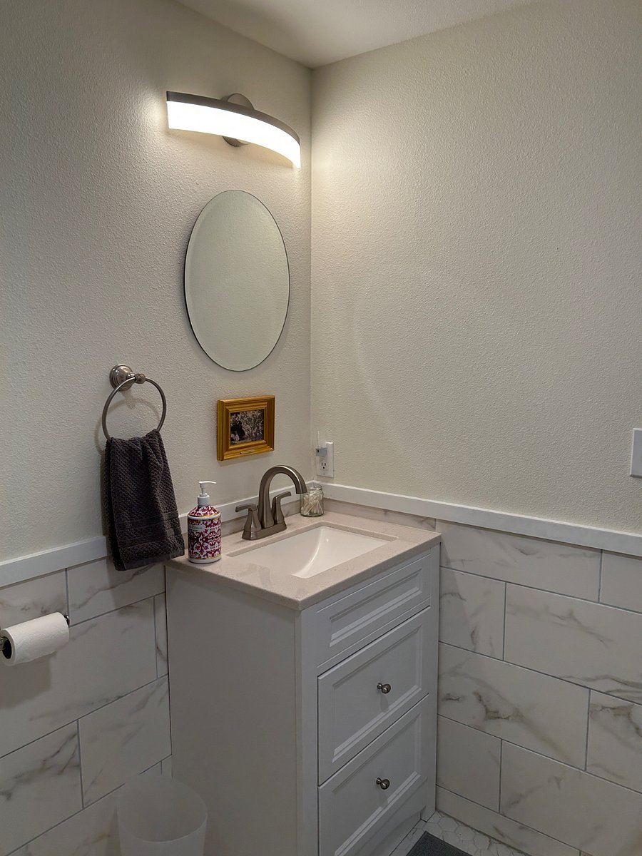 Bathroom sink and mirror. Towels and hairdryer are provided. 