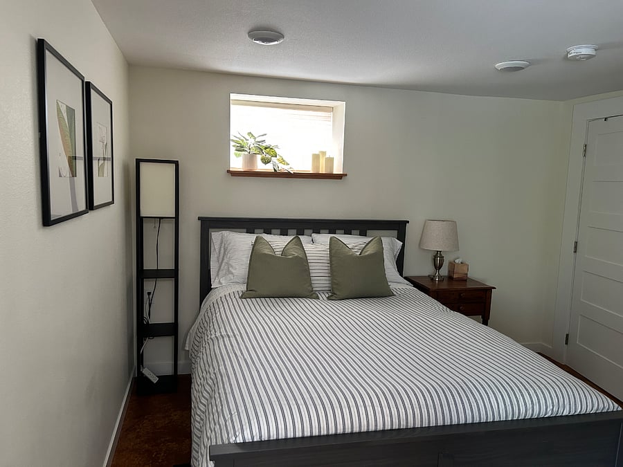 Comfortable queen-sized bed with bedding, and easy access to outlets to recharge electronics.