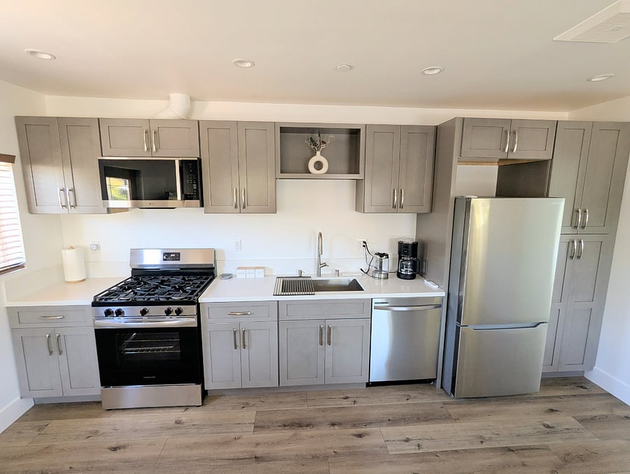 Full Kitchen with stove and oven, microwave, dishwasher, coffee maker, kettle, fridge, freezer.