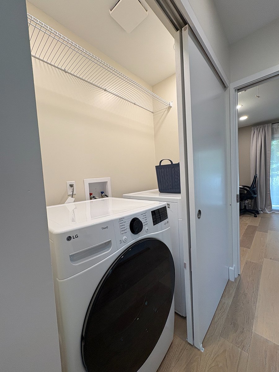 Hall closet with full size washer and dryer, overhead clothes drying rack