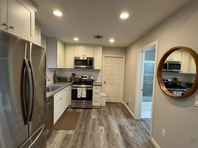Modern kitchen with main bathroom adjacent and closed door to Bedroom 1 shown