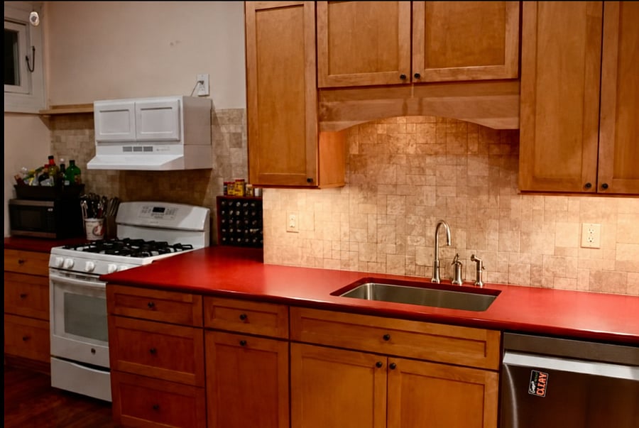 Kitchen with heritage gas stove, all new stainless steel dishwasher and refrigerator, and small appliances including electric kettle.