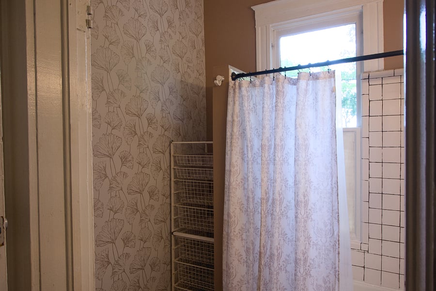 Adjoining bathroom between two bedrooms with storage, bath and shower. 