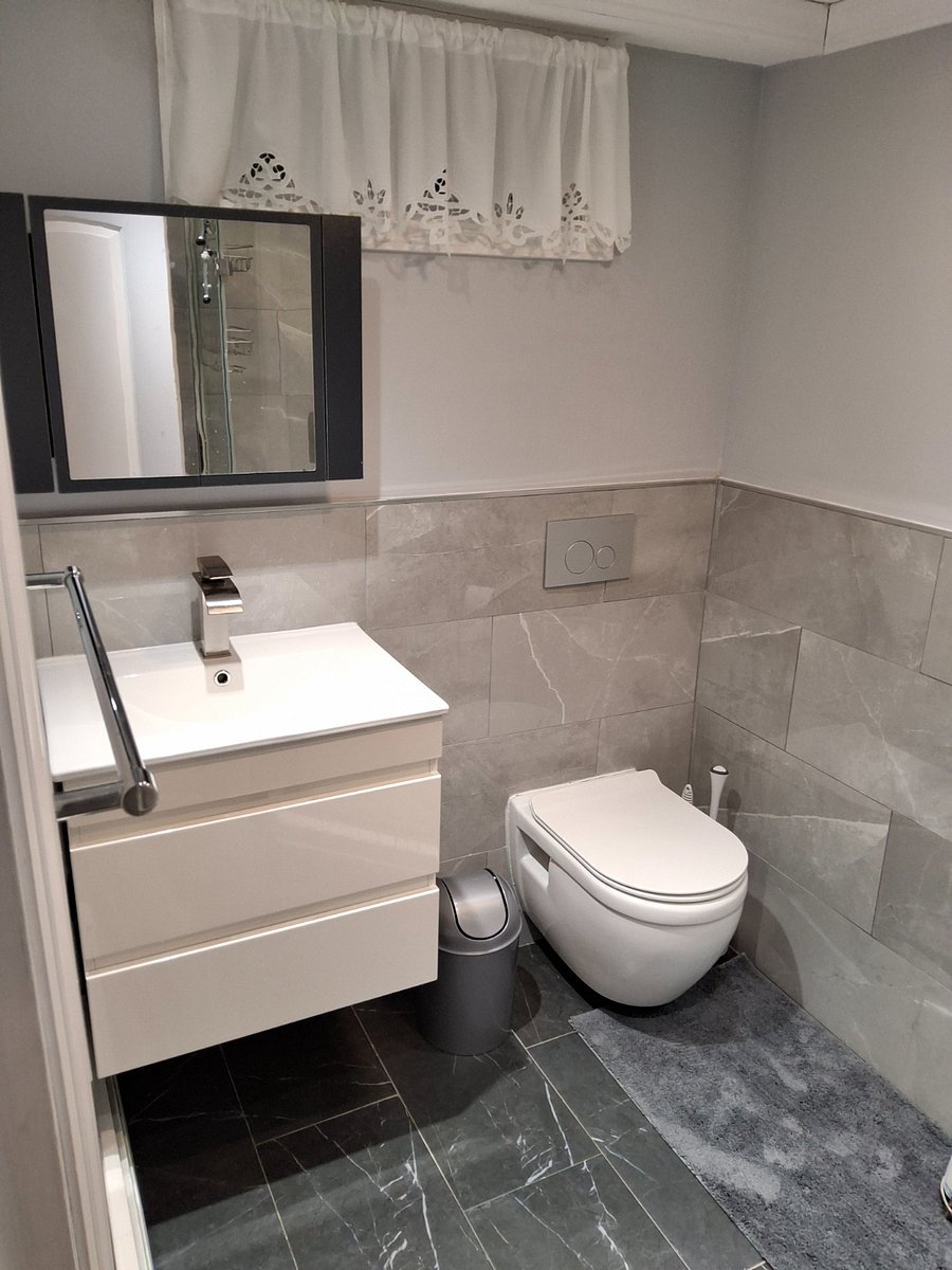 Updated bathroom with a floating sink, toilet, and rain shower.