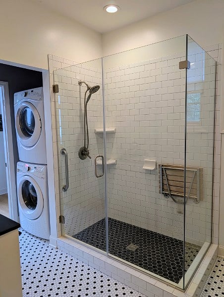 A washer and dryer are tucked behind the shower, which is roomy and equipped with grab bars and a fold-down bench.