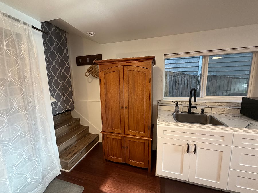 There are a few stairs behind the gray curtain for additional storage.