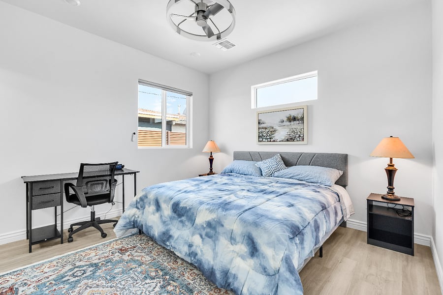Spacious primary suite featuring a comfortable king bed, dedicated workspace, and ensuite bathroom for added privacy.