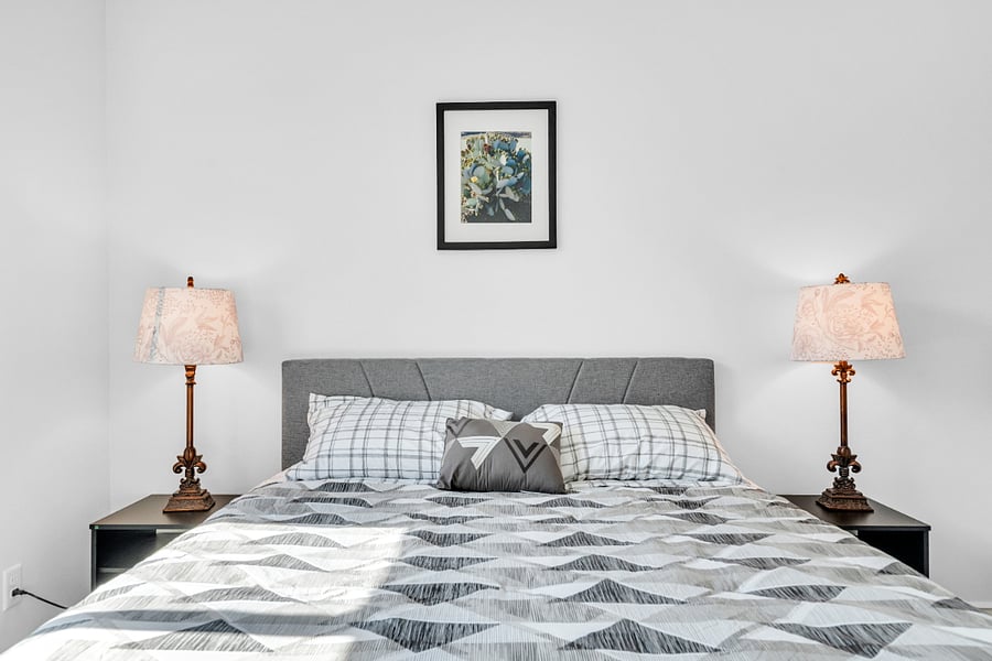 Peaceful guest bedroom with a cozy queen bed, soft lighting, and plenty of space to unpack and unwind.
