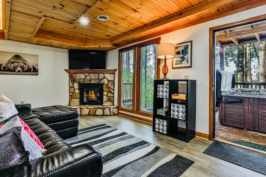 Second living space on lower level with fireplace and board games. Large smart TV. Opens into a deck with the covered private hot tub. 