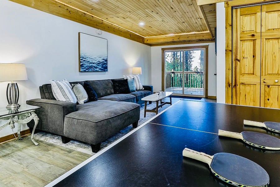 The lower level has 2 sectionals with multiple hang out spaces and a ping pong table for your enjoyment. This couch has a fantastic view as well and opens into a deck with the fire-pit. 