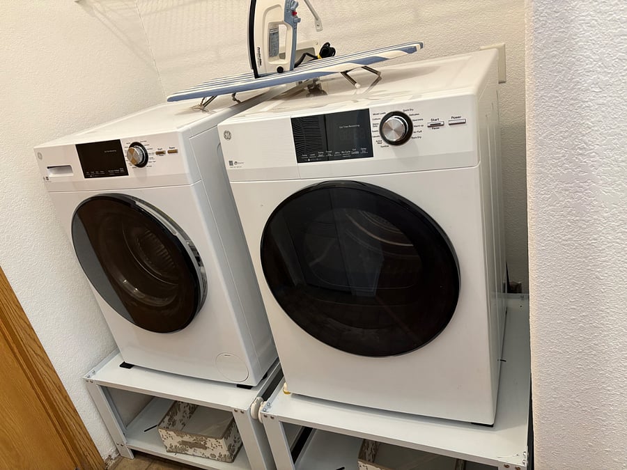 Raised Washer+Dryer, ironing board and iron.