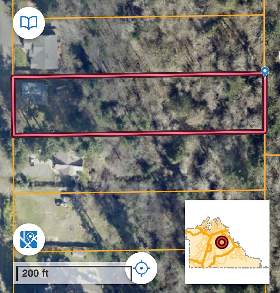 The house and garage are in shadow. The property extends all the way down to the bottom of the hill. Deer paths and a giant boulder are some of what is down there.