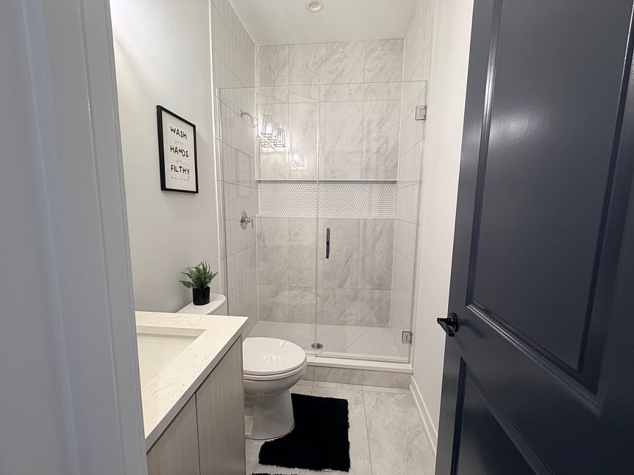 Clean and updated bathroom with a shower/tub combination, fresh linens, and convenient storage for personal items.