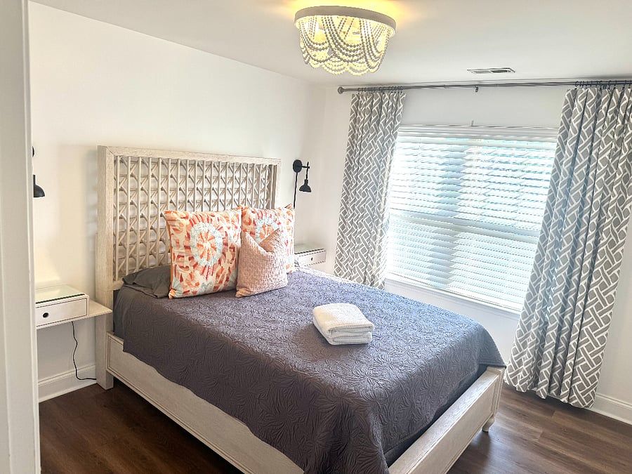 Queen bed upstairs with lots of natural light and blackout curtains.
