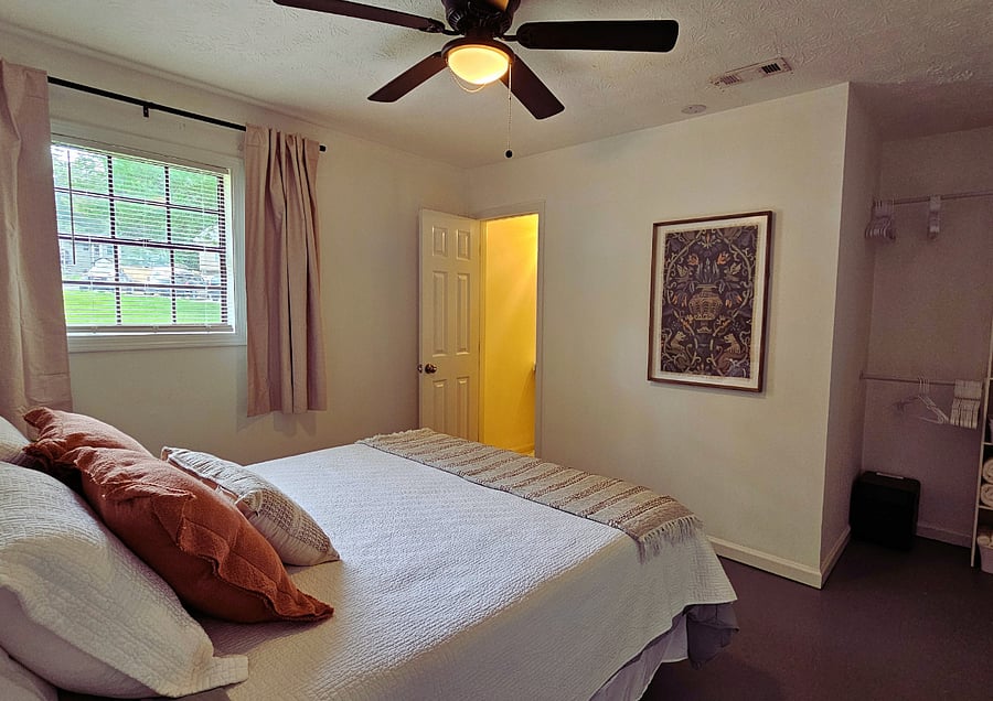 The room-darkening curtains open fully to allow natural sunlight into the room.