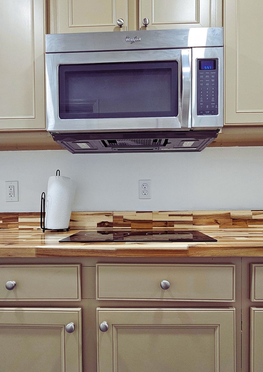 An electric two burner cook top and large microwave with built-in vent fan.