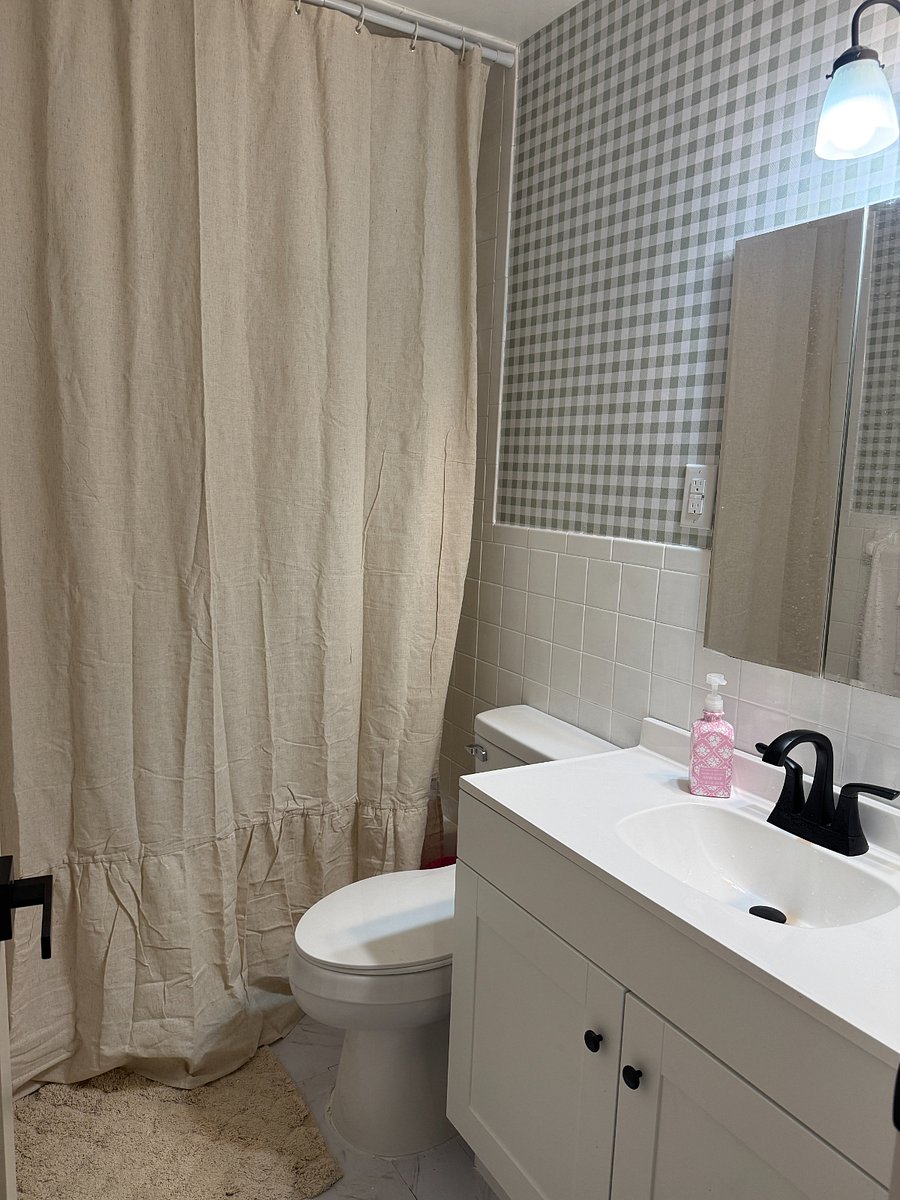 Main floor full bath tub and shower with new toilet and sink cabinet.