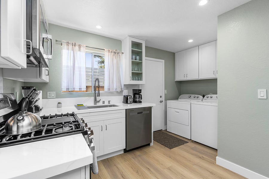 The kitchen is well stocked with cookware, utensils, silverware, and glassware.