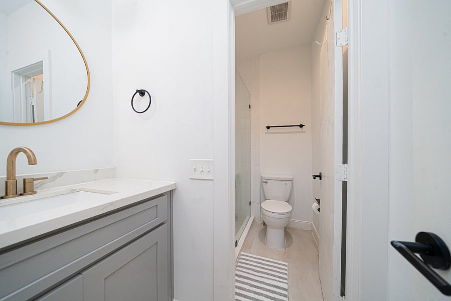 Updated full bathroom featuring a spacious vanity, storage, modern finishes and a walk-in shower.