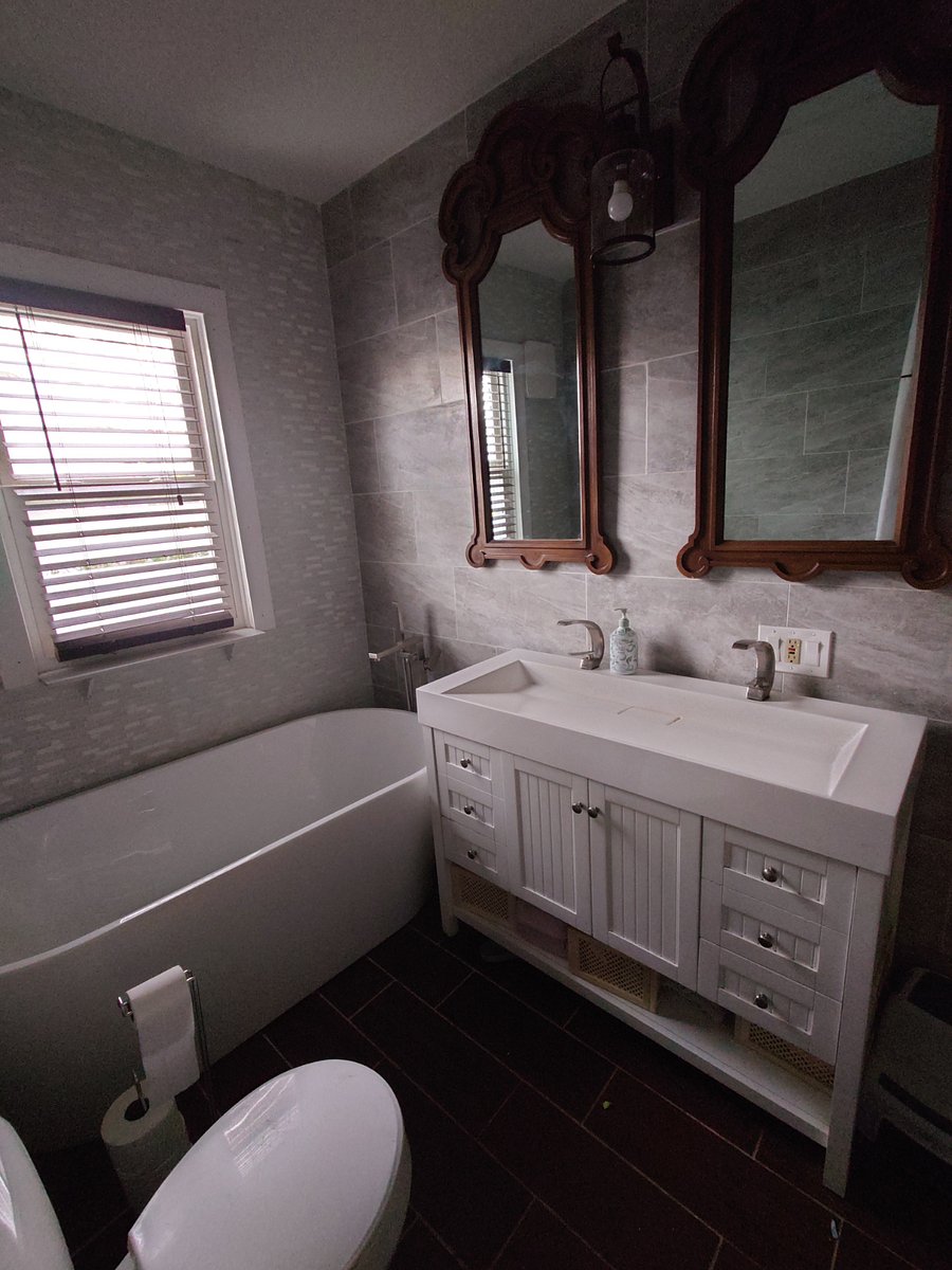Downstairs shared bathroom with double sink, soaking tub and rain shower